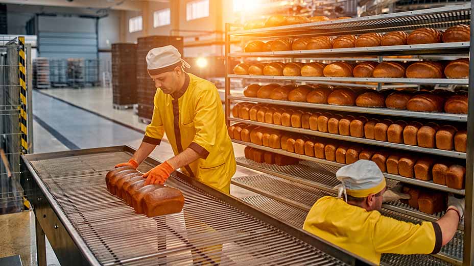 Two workers making bread