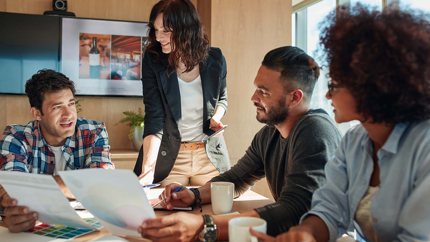 Team of colleagues brainstorming in meeting room with color palettes